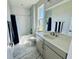 Beautiful bathroom features a tub and shower combination and gray cabinets with silver hardware at 16832 Bolsena Dr, Bella Collina, FL 34756