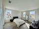 Bright bedroom with hardwood floors, three windows, and neutral wall colors create a relaxing atmosphere at 16832 Bolsena Dr, Bella Collina, FL 34756