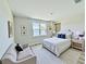 Bright bedroom featuring a large window with water views and comfortable seating area at 16832 Bolsena Dr, Bella Collina, FL 34756