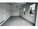 Spacious garage with finished floors, bright windows, and an automatic door opener at 16832 Bolsena Dr, Bella Collina, FL 34756