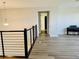 Upstairs hallway with modern railings, showing a piano and with neutral decor at 16832 Bolsena Dr, Bella Collina, FL 34756