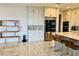 Bright kitchen featuring custom cabinets, stainless steel appliances, a large island, and modern marble floors at 16832 Bolsena Dr, Bella Collina, FL 34756
