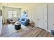 Bright living room showcasing a blue sofa, stylish decor, and wood-look flooring that exudes modern elegance at 16832 Bolsena Dr, Bella Collina, FL 34756