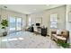 Well-lit office with a modern desk, comfortable seating, and a sliding glass door with serene water views at 16832 Bolsena Dr, Bella Collina, FL 34756