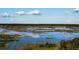 Scenic aerial view of a sprawling marsh landscape under a bright blue sky with scattered clouds at 11990 Se 112Th Avenue Rd, Belleview, FL 34420
