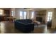 Open-concept living room featuring a stone fireplace, tile flooring, and natural light from large windows at 11990 Se 112Th Avenue Rd, Belleview, FL 34420