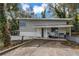 View of the home's exterior with lawnmower parked on the front porch and driveway in front at 1630 Lakeview Ct, Eustis, FL 32726