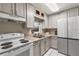 Bright kitchen equipped with white appliances, gray cabinetry, and a window view at 1630 Lakeview Ct, Eustis, FL 32726