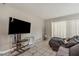 Living room area features couch, TV, shelving, and sliding glass doors at 1630 Lakeview Ct, Eustis, FL 32726