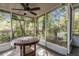 Enclosed patio featuring a ceiling fan, table and view of the landscaped yard at 1630 Lakeview Ct, Eustis, FL 32726