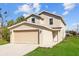 Charming two-story home featuring a beige exterior, two-car garage, and well-manicured front lawn at 1132 Avenue K # A, Haines City, FL 33844