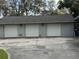 Three-car garage with white doors, exterior lighting, and driveway at 1818 Lago Ct, St Cloud, FL 34769