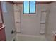 Bathroom featuring a tub with shower, a window for natural light, and built in storage shelves at 335 N Causeway # E3, New Smyrna Beach, FL 32169