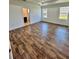 Bright main bedroom with wood-look flooring and views from two windows, with ensuite bathroom entrance at 1314 Congo Ct, Poinciana, FL 34759