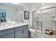 Bright bathroom featuring a single vanity, gray cabinets, and a glass-enclosed shower at 2549 Penguin Blvd, Davenport, FL 33837
