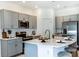 Well-lit kitchen showcases gray cabinets, stone countertops, stainless steel appliances, and a central island at 2549 Penguin Blvd, Davenport, FL 33837