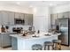 Kitchen featuring stainless steel appliances, stone countertops, a center island with seating, and gray cabinets at 2549 Penguin Blvd, Davenport, FL 33837