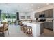Open-concept kitchen with an island, stainless steel appliances, gray cabinets, and breakfast bar with seating at 2549 Penguin Blvd, Davenport, FL 33837