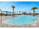 Community pool area with zero entry, splash fountain, and beautiful palm trees at 2549 Penguin Blvd, Davenport, FL 33837