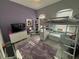Fun bedroom with a loft bed, a desk, a TV, and a plush purple rug creating a playful and inviting space at 3345 Tesoro Cir, New Smyrna Beach, FL 32168