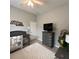 Comfortable bedroom features a crib, TV and a soft area rug, creating a tranquil and inviting space for rest and relaxation at 3345 Tesoro Cir, New Smyrna Beach, FL 32168