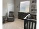 Cozy Bedroom with a crib, a glider chair, and soft rug creating a comfortable and peaceful environment for baby at 3345 Tesoro Cir, New Smyrna Beach, FL 32168