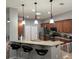 A kitchen with wood cabinets, stainless steel appliances, pendant lights, and a breakfast bar with granite countertops at 3345 Tesoro Cir, New Smyrna Beach, FL 32168