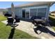 Outdoor patio with beautiful pavers, furniture, and an umbrella to provide shade on sunny days at 3345 Tesoro Cir, New Smyrna Beach, FL 32168