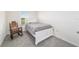 This bedroom features a white bed, rocking chair, and window at 6677 Sw 81St Loop, Ocala, FL 34476