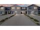 Modern townhome exterior features multiple units with attached garages, tidy landscaping, and long driveways at 6677 Sw 81St Loop, Ocala, FL 34476