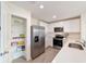 Well-organized kitchen with stainless steel refrigerator, modern appliances, and pantry at 6677 Sw 81St Loop, Ocala, FL 34476