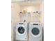 This functional laundry room features modern, front-load washer and dryer units with a wire rack above at 6677 Sw 81St Loop, Ocala, FL 34476