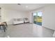 Well-lit living area with access to the backyard, featuring minimalist furniture and tiled flooring at 6677 Sw 81St Loop, Ocala, FL 34476