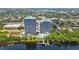 Aerial view of condo towers with pool, dock and lake view surrounded by lush greenery at 13415 Blue Heron Beach Dr # 1407, Orlando, FL 32821