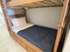 Close-up of a bunk bed showcasing the bottom bunk with storage drawers and a navy blue comforter at 13415 Blue Heron Beach Dr # 1407, Orlando, FL 32821