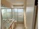 Bathroom featuring a vanity with dual sinks and a glass-enclosed shower, perfect for a functional and elegant space at 636 Birgham Pl, Lake Mary, FL 32746