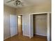 Cozy bedroom featuring hardwood floors, closet with bi-fold doors, and a ceiling fan for added comfort at 636 Birgham Pl, Lake Mary, FL 32746