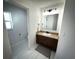 Clean bathroom featuring white tiled floors, modern vanity, and contemporary light fixtures at 9233 Tom Moore Rd, Lakeland, FL 33810