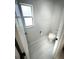 This bathroom features white tile flooring, a toilet, and a window for natural light at 9233 Tom Moore Rd, Lakeland, FL 33810