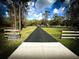 Long driveway leading to a beautiful home surrounded by a lush, green landscape and mature trees at 9233 Tom Moore Rd, Lakeland, FL 33810