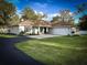 Charming single-story home with well-manicured lawn, circular driveway, and attached two-car garage at 9233 Tom Moore Rd, Lakeland, FL 33810