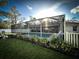 Backyard view of a sparkling screened-in pool with lush landscaping, and well-maintained lawn at 9233 Tom Moore Rd, Lakeland, FL 33810