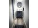 Small powder room with gray vanity, round mirror and decor at 9233 Tom Moore Rd, Lakeland, FL 33810