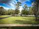 Expansive green lawn and mature trees surrounding the home with a long, paved driveway at 9233 Tom Moore Rd, Lakeland, FL 33810