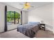 Comfortable bedroom featuring a ceiling fan, carpet, and a large window with outdoor views at 6121 Metrowest Blvd # 103, Orlando, FL 32835