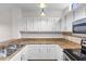 Bright, clean kitchen features white cabinetry, granite countertops, and stainless steel appliances at 6121 Metrowest Blvd # 103, Orlando, FL 32835