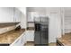 Modern kitchen featuring stainless steel refrigerator, granite counters, and white cabinets for storage at 6121 Metrowest Blvd # 103, Orlando, FL 32835