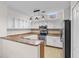 Bright kitchen features white cabinetry, granite countertops, stainless steel appliances, and hardwood floors at 6121 Metrowest Blvd # 103, Orlando, FL 32835