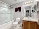 Bright bathroom featuring a glass shower, toilet, vanity with sink, and decorative wall art at 2634 Andros Ln, Kissimmee, FL 34747