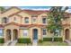 Townhome exterior boasts terra cotta roof, neutral paint, well-manicured landscaping, and inviting facade at 2634 Andros Ln, Kissimmee, FL 34747